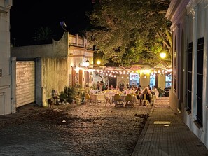 An outdoor dining area with tables and chairs, surrounded by buildings and trees. - Cozy Apartment historic neighborhood (Colonia del Sacramento)