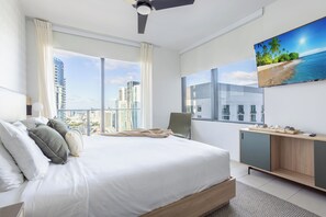 A modern hotel room with a large bed, a desk, and a city view. - 41st-Floor Downtown Apt with Bay and Skyline Views 4101 (Miami)