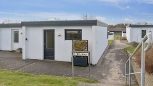 A row of white mobile homes with a clear sky. - Cosy small holiday apartment for 4 persons (Tranekær)
