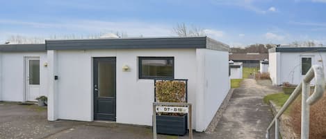 Une rangée de maisons mobiles blanches, avec un ciel dégagé.