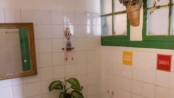 Chuveiro, toalhas de banho, sabonete, papel higiênico
