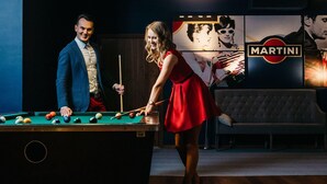 A pool table with balls, a sofa, and a Martini logo in the background. - Novotel Olsztyn (Olsztyn)