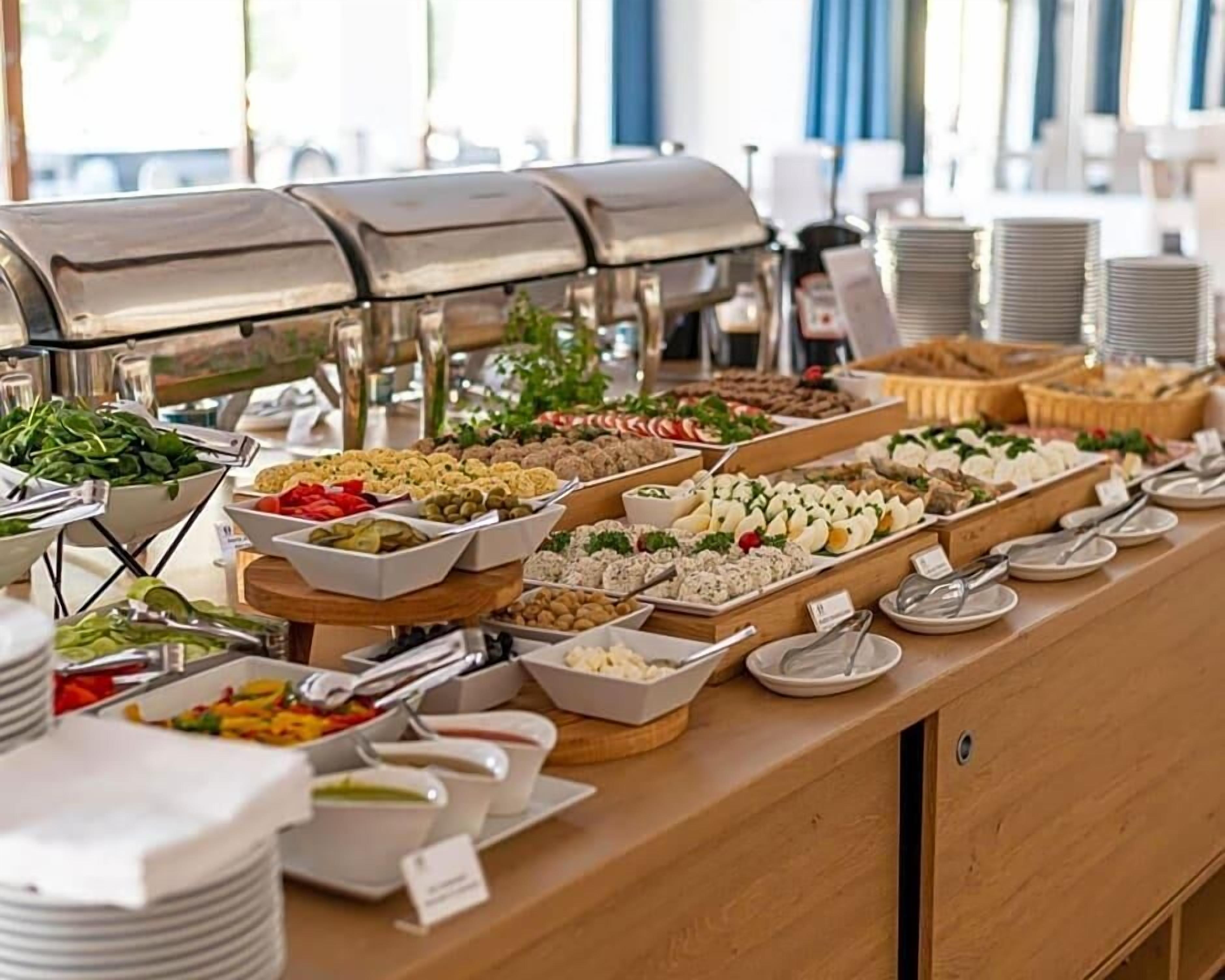 A buffet with various food items and a grill station.