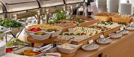 A buffet with various food items and a grill station.