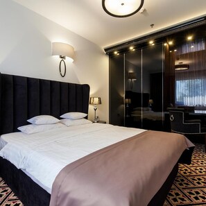 Een moderne hotelkamer met een groot bed, een spiegel, een bureau en uitzicht op de stad.
