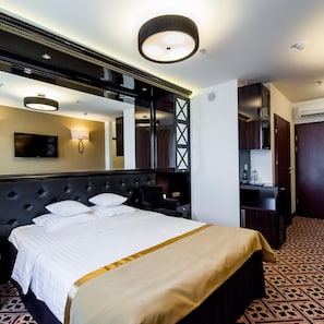 A hotel room with a large bed, a TV, a mirror, and a desk with a chair. - Hotel 500 Zegrze (Nieporet)