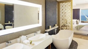 A modern hotel room with a large bathroom, a bed with a view of the ocean, and a balcony with a hammock. - Modern 1-bedroom hotel suites in charming Cancun  Mexico (Cabo San Lucas)