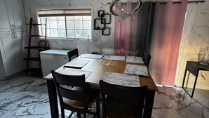 A dining area with a marble floor, a wooden table, and chairs. There is a window with blinds, a chandelier, and a pink curtain. - 3-bedroom house in enchanting in  LA with AC  fitness area and swimming pool (Los Angeles)