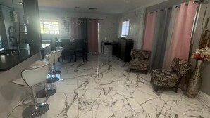 A spacious living area with a marble floor, a dining area with a table and chairs, and a kitchen with modern appliances. - 3-bedroom house in enchanting in  LA with AC  fitness area and swimming pool (Los Angeles)