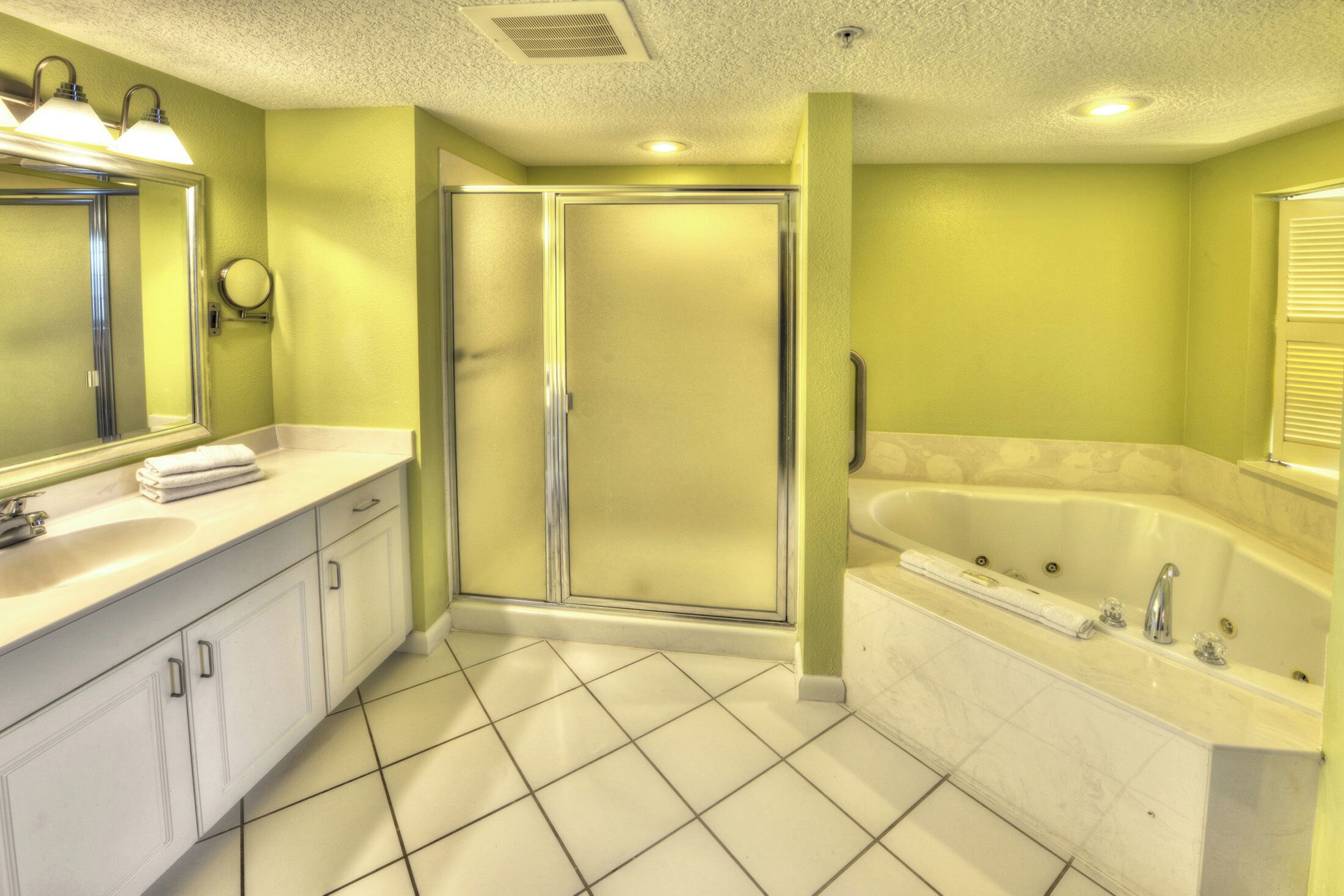 A bathroom with a white sink, mirror, and bathtub.