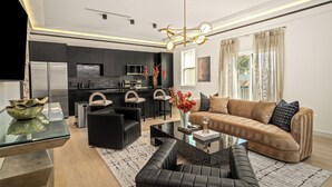 Een moderne woonkamer met een bank, salontafel en een glazen tafel met een decoratieve schaal.