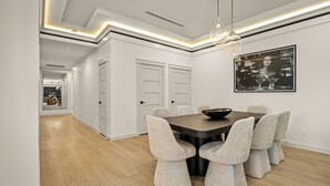 A modern dining area with a dark wooden table, six upholstered chairs, and a large black and white artwork on the wall. - Resort-Style 5BR Ensuites •Slps10 •Pool&Spa •Gated (Houston)