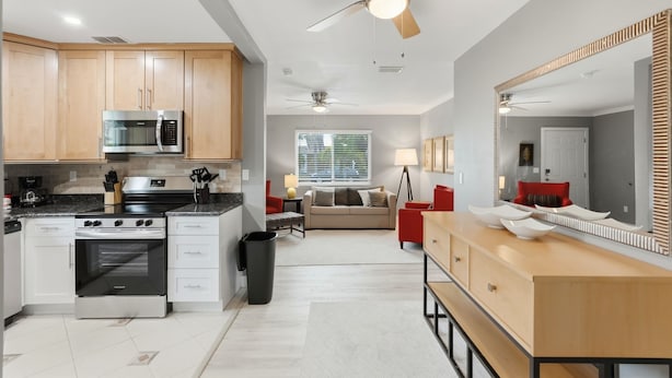 Een moderne keuken met roestvrijstalen apparatuur, houten kastjes en een centraal eiland.