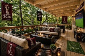 An outdoor lounge area with sofas, a fire pit, and FIFA World Cup 2026 decorations.