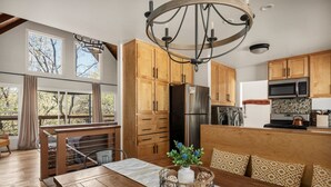 A modern kitchen with wooden cabinets, a stainless steel refrigerator, and a built-in oven.