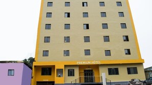 A multi-story building with a yellow facade and a sign reading "PREMIUM HOTEL". - Premium HOTEL (Douala)