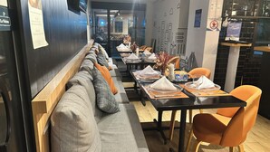 Een restaurant met een lange toonbank, zachte zitplaatsen en een modern interieur.