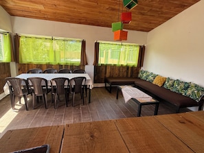 A dining area with a table and chairs, a bench, and a sofa with cushions.