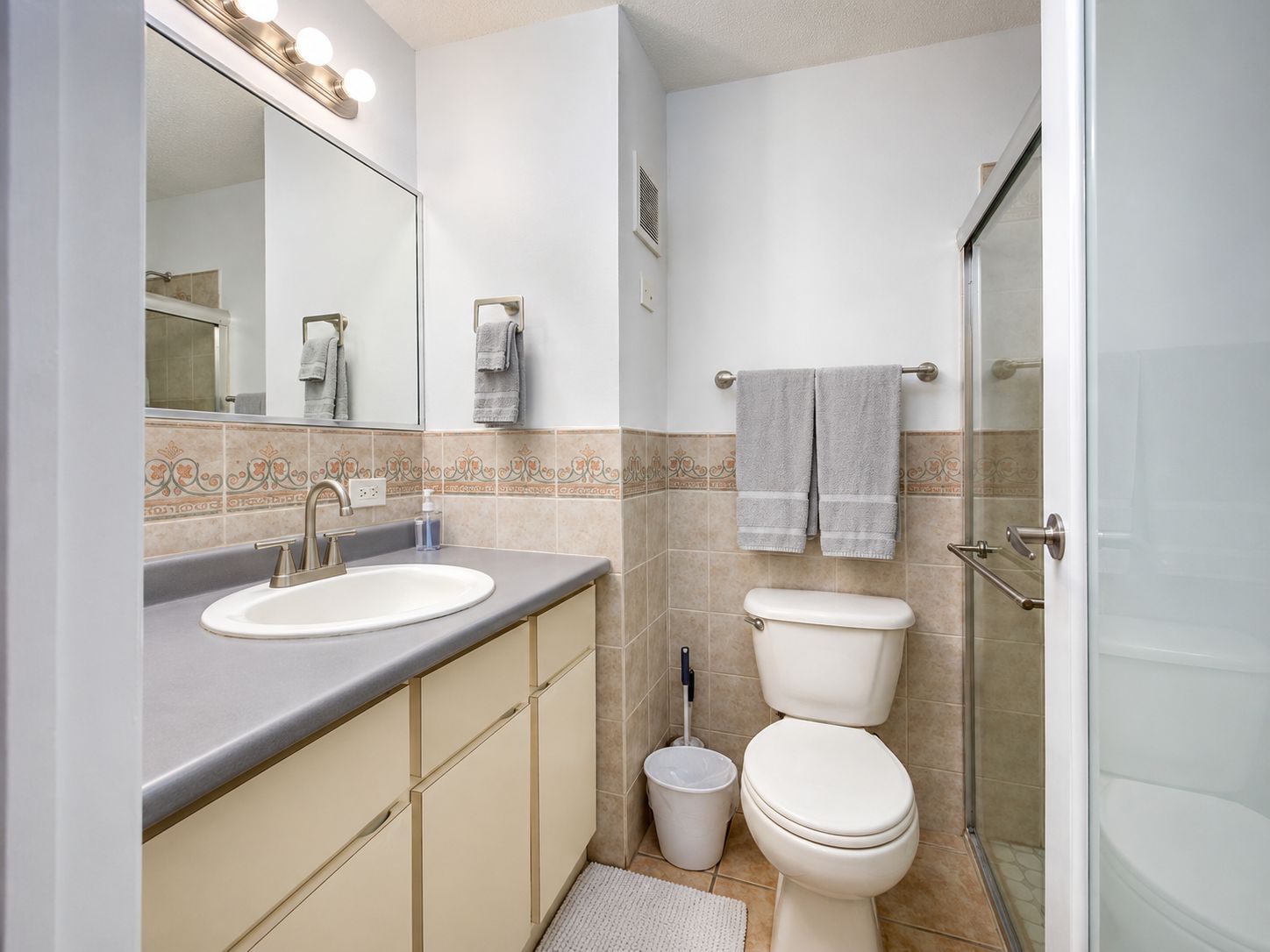 Un baño con lavamanos, inodoro y ducha.