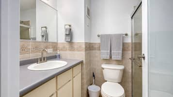 Un baño con lavamanos, inodoro y ducha.