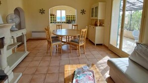 Un espacio habitable amplio con una mesa de comedor, sillas, un sofá y una cocina al fondo.