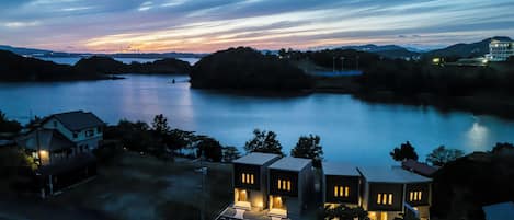 A lakeside property with modern houses, a parking area, and a view of the water.