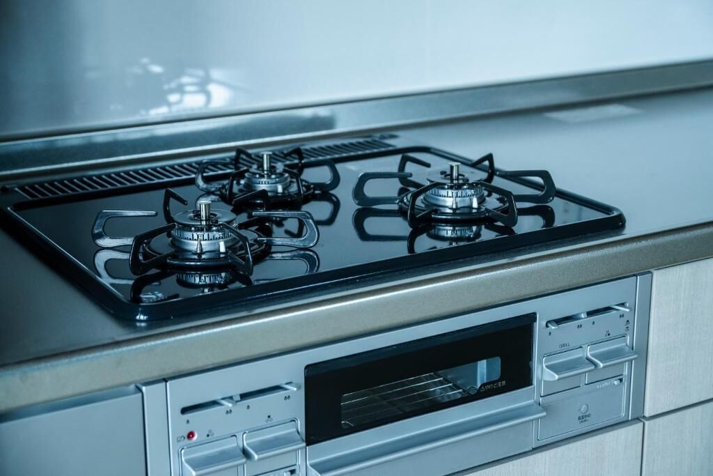 A kitchen with four gas burners and a built-in oven.