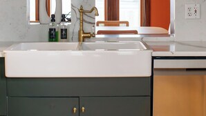 A modern bathroom with a marble sink, dark cabinets, and a large mirror. - The Wunderhaus – 4BR Minneapolis Escape (Minneapolis)