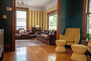 Ein Wohnzimmer mit einem braunen Sofa, einem gelben Sessel und einem Couchtisch.