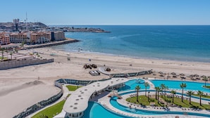 Un complexe hôtelier doté d’une grande piscine, d’une plage et offrant une vue sur l’océan.