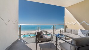 Un balcon avec vue sur la plage, une piscine et un canapé.