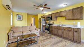 A compact kitchen with wooden cabinets, a built-in microwave, and a refrigerator.