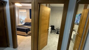 Ein Hotelzimmer mit Bett, Schreibtisch und Fernseher.