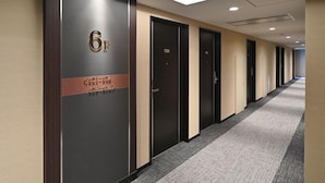 A hotel corridor with numbered doors, a carpeted floor, and recessed lighting. - Hotel Trend Suzuka (Suzuka)