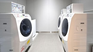 A laundry facility with two front-loading washing machines and a control panel on top. - Hotel Trend Suzuka (Suzuka)