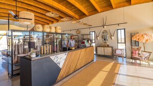 A modern interior with a wooden ceiling, a reception desk, and a seating area with a decorative plant. - The Desert Grace, Gondwana Collection Namibia (pty (Sesriem)