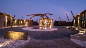 A modern building with a circular courtyard, a central water feature, and directional signs. - The Desert Grace, Gondwana Collection Namibia (pty (Sesriem)