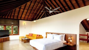 A spacious bedroom with a large bed, a wooden ceiling, a TV, a sofa, and a TV stand. - Kandy Knightsdale Villa (Menikhinna)