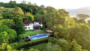 A house with a swimming pool surrounded by lush greenery and hills. - Kandy Knightsdale Villa (Menikhinna)
