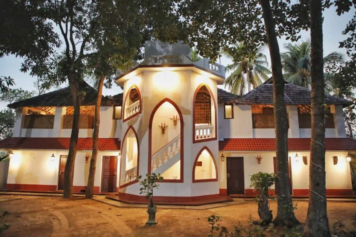A two-story building with a central tower, multiple windows, and a staircase leading to the upper floor.