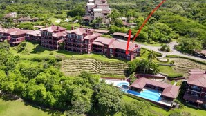 Et resort med flere bygninger, en swimmingpool og terrasseret have.