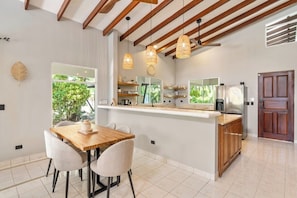 A modern kitchen with a central island, wooden ceiling beams, and pendant lighting. - 4BR Tropical Retreat • Pool • Beach • Golf Cart (Playa Potrero, Santa Cruz)