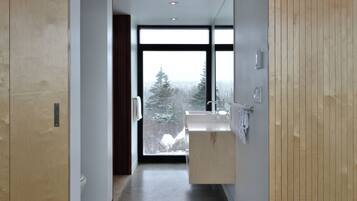 Un bagno moderno con un'ampia finestra, un mobile bagno in legno e uno specchio.