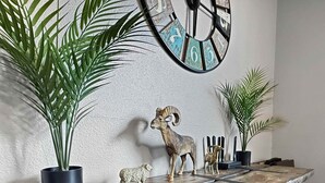 A rustic wooden table with decorative animal figurines and a wall clock. - Two Homes walk to Convention Ctr Hot Tub Game room (Branson)