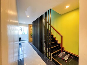 Un interior moderno con una escalera, un pasillo y una pared con textura.