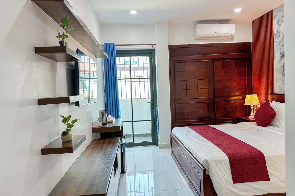 Un dormitorio moderno con cama, mesita de noche, estanterías y ventana con cortinas.