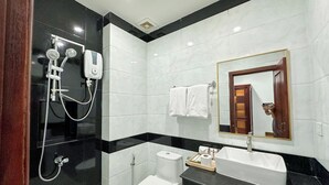 Een moderne badkamer met douche, toilet en wastafel.