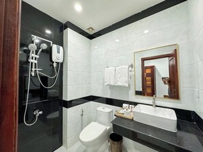 Un baño moderno con ducha, inodoro y lavamanos.