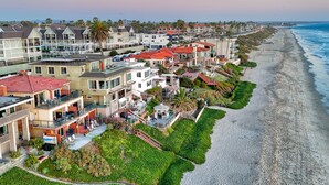 Zona residencial costera con casas a lo largo de la playa, con balcones y vista al océano.