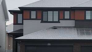 Une maison à deux étages avec un garage, une façade en briques et une porte de garage portant le numéro 539.